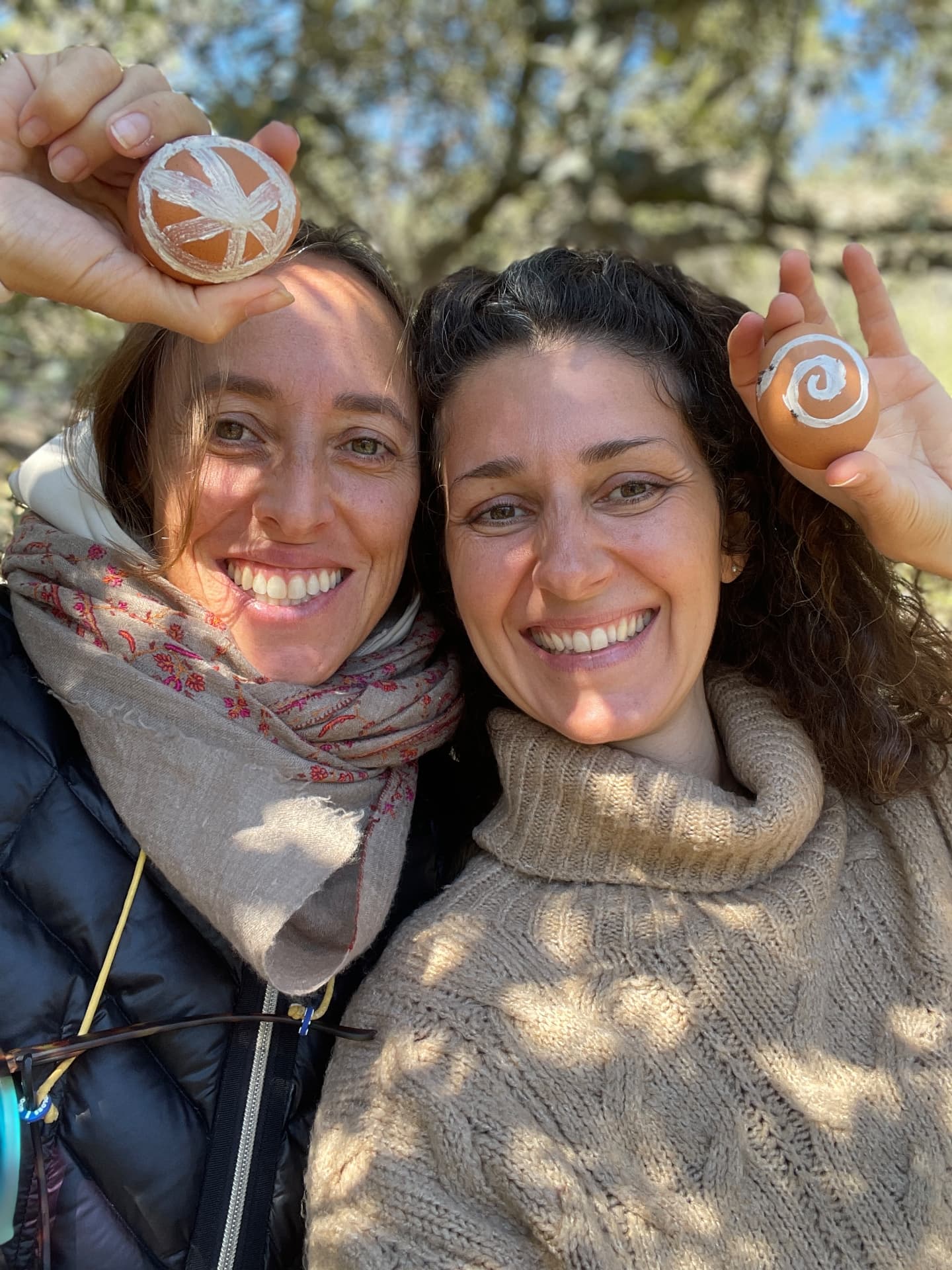 Dos personas sonrientes con objetos rituales